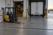 A forklift parked beside a warehouse trailer-loading dock